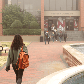 Student walking toward SNU's Webster Commons