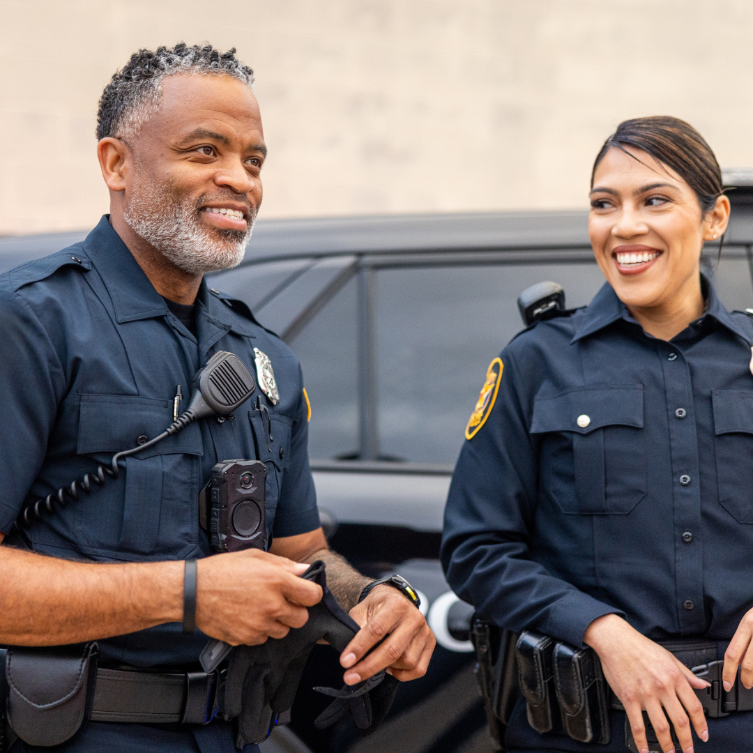 Male Police Officer with female Police Officer Standing In Front of Car