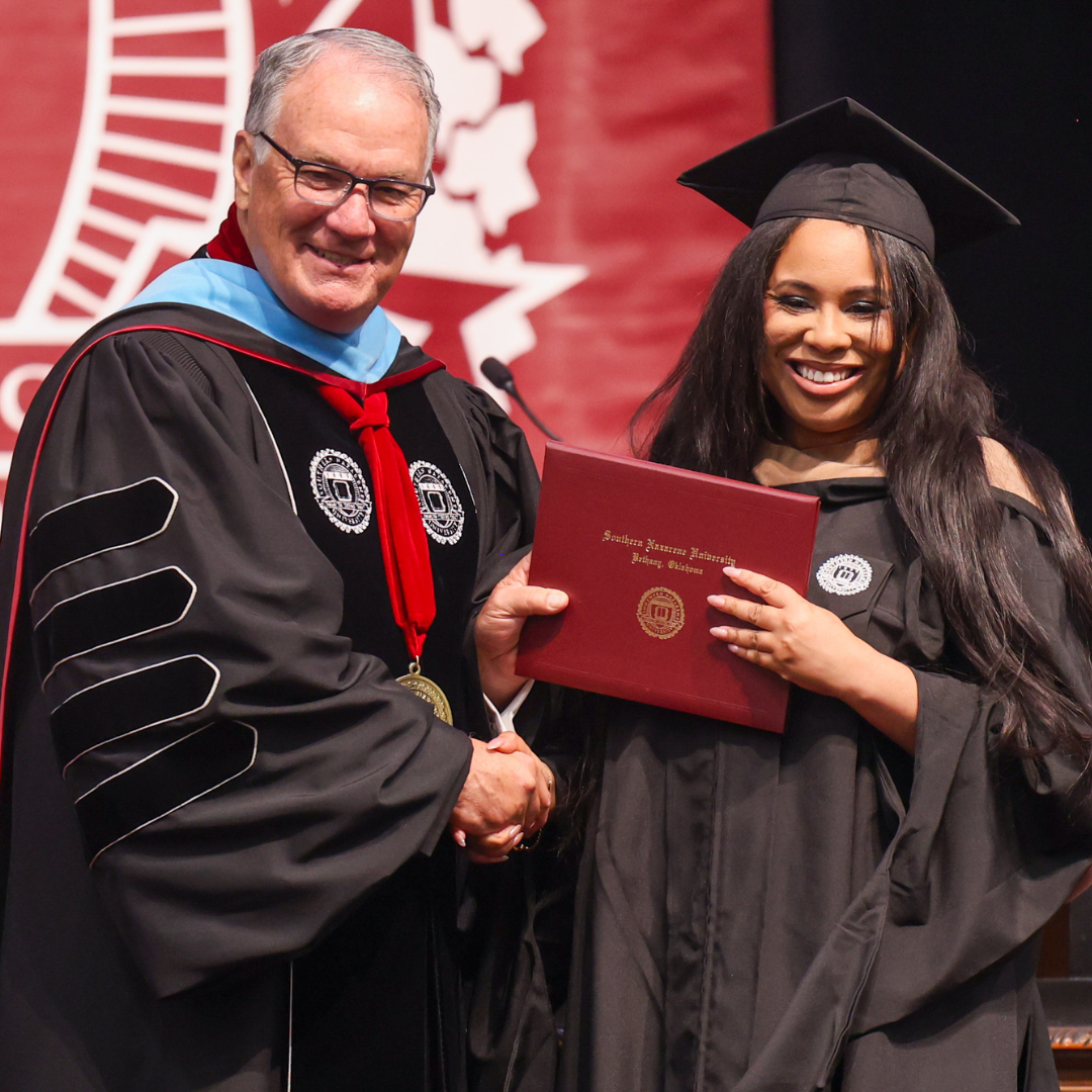 SNU President Dr. Keith Newman congratulating an MBA graduate.