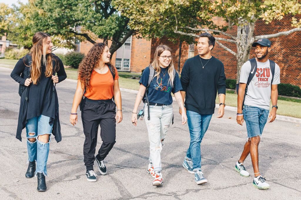 Group of students walking across campus in the fall