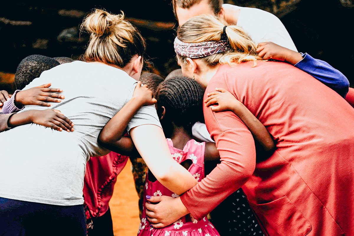 Students hug children on mission trip