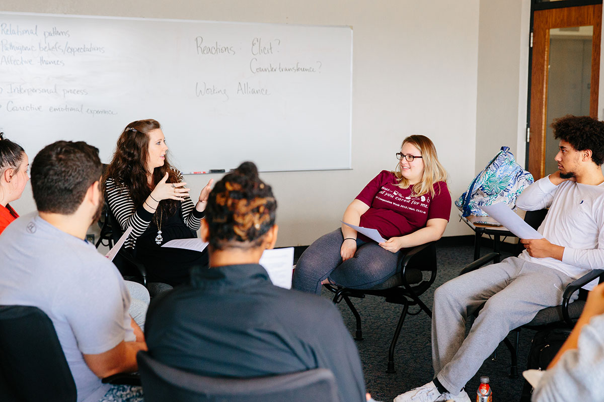 Students and professor discuss in classroom