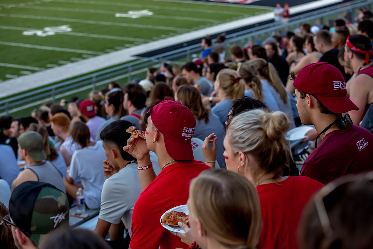 Students in football stands wearing SNU gear