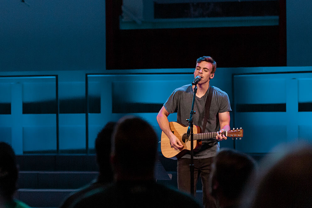 Student leading worship on stage