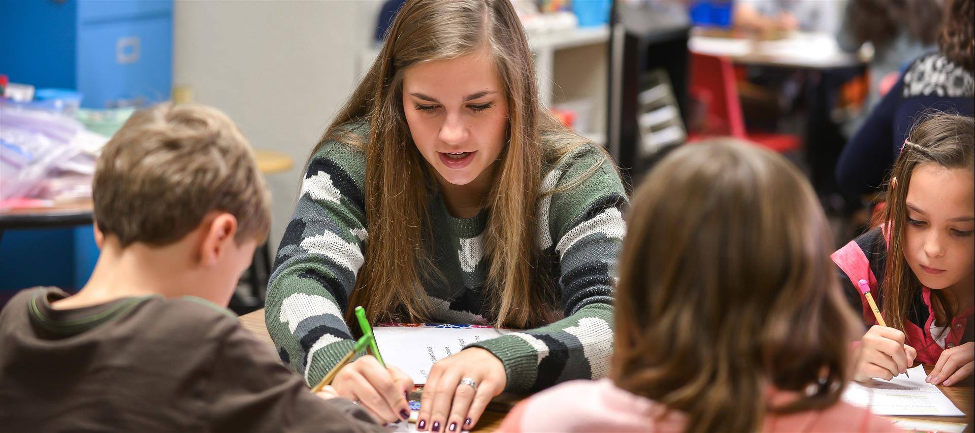 Teacher working with students at a table