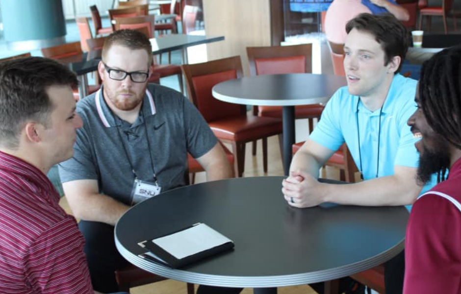 Three students sitting around a table.