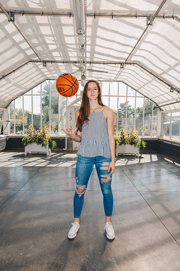 women's basketball player  throwing ball up in the air