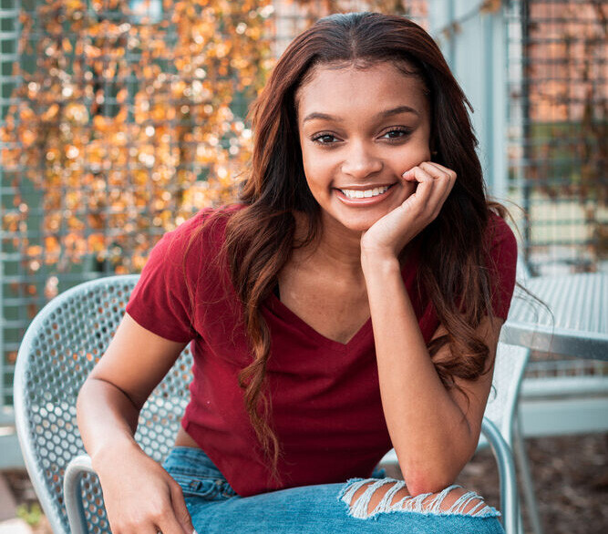 young female student sitting outside at a table