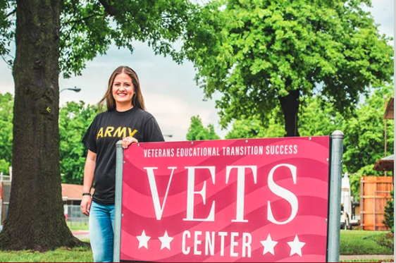 Veteran Student standing by VETS Center sign