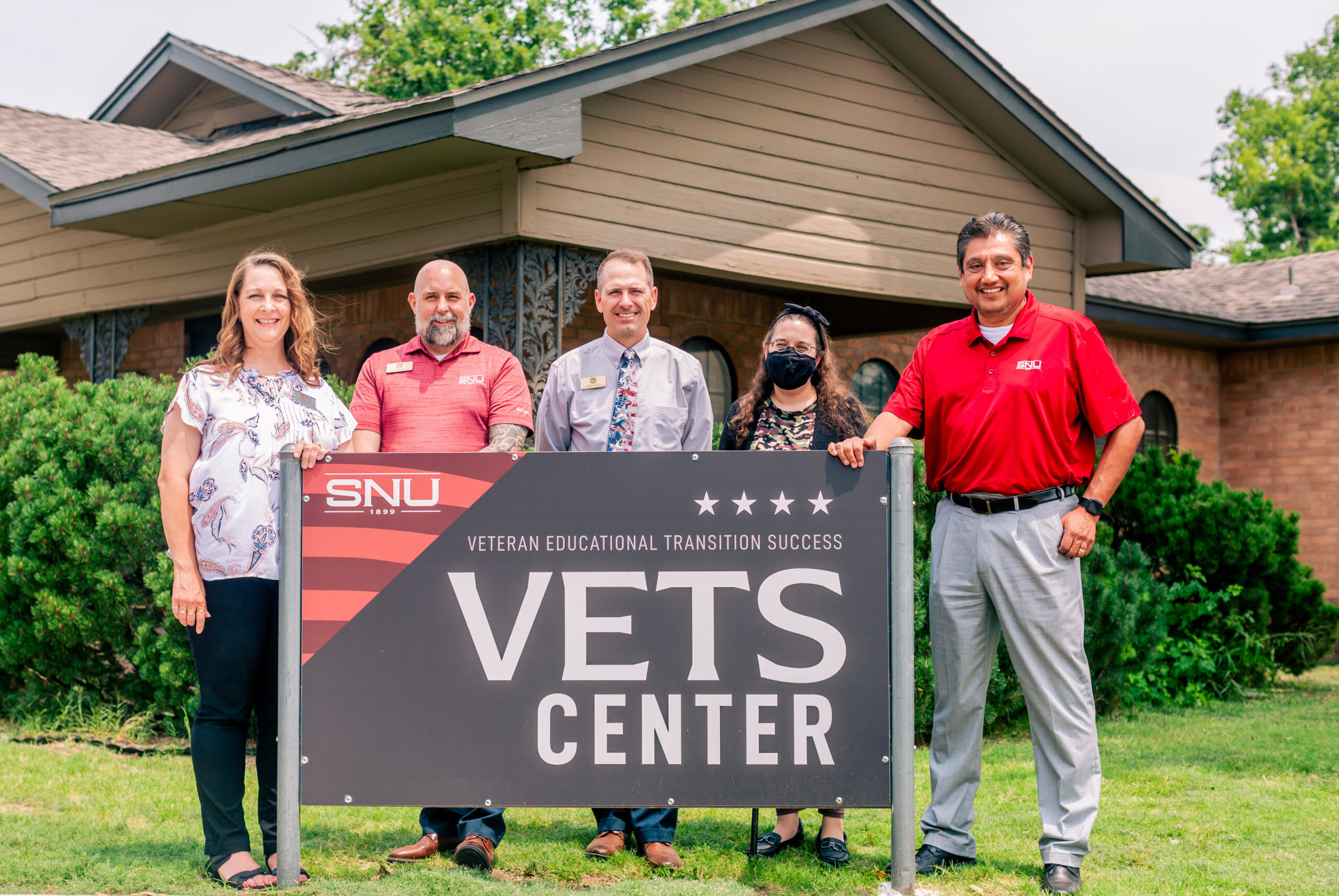 VETS Center Personnel standing outside the VETS Center Sign