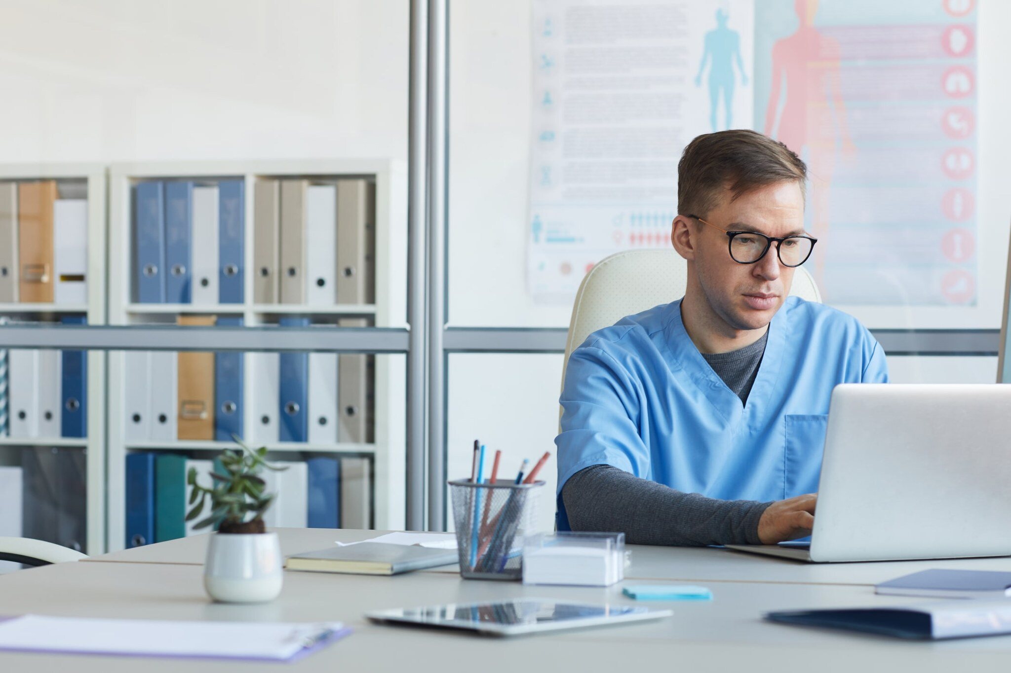 health care worker sitting at laptop