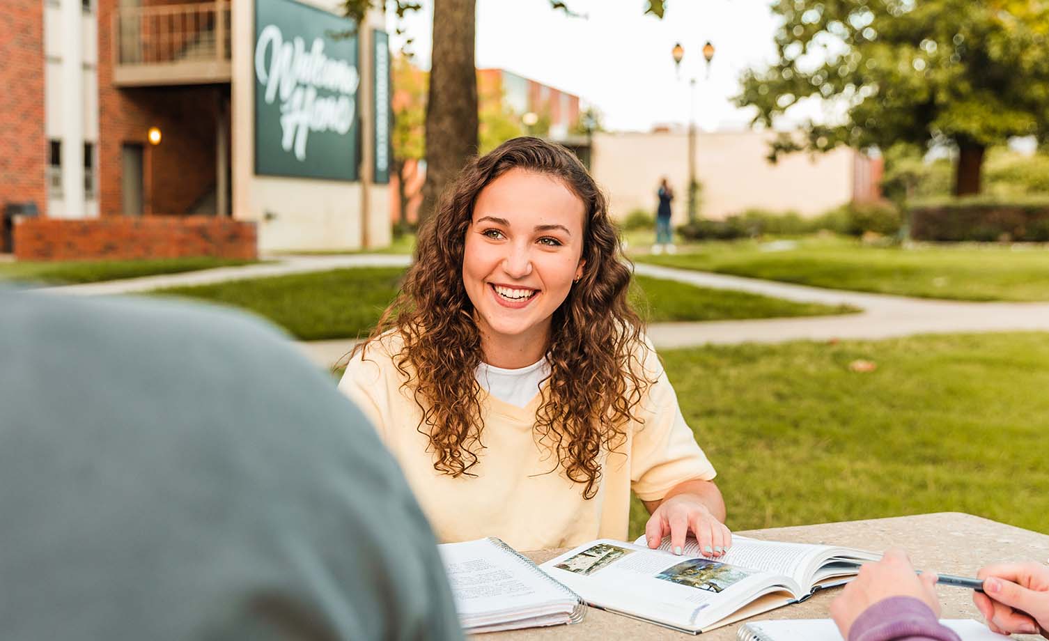 Girl sitting at picnic table working on homework