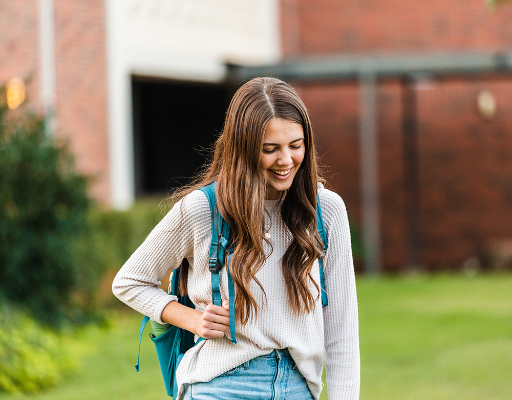 student walking outside on campus