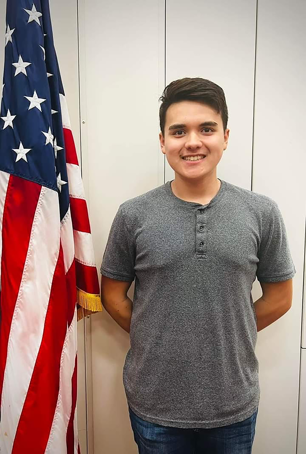 student standing by flag