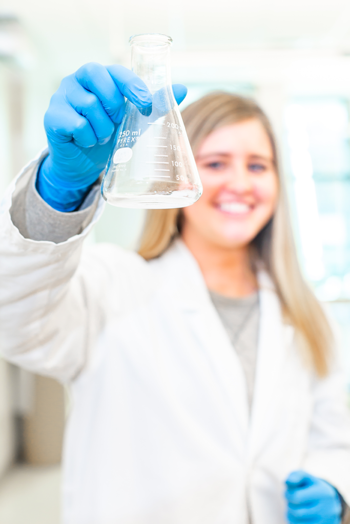 student holding beaker in science lab
