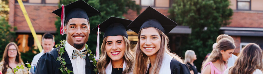 three SNU Graduates smiling in regalia