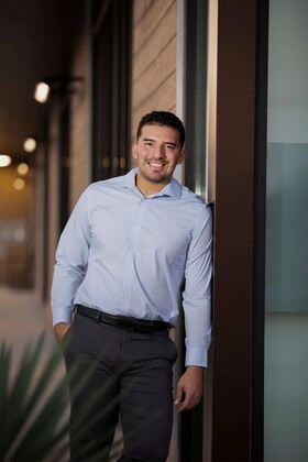 brandon perez smiling and standing leaning on wall