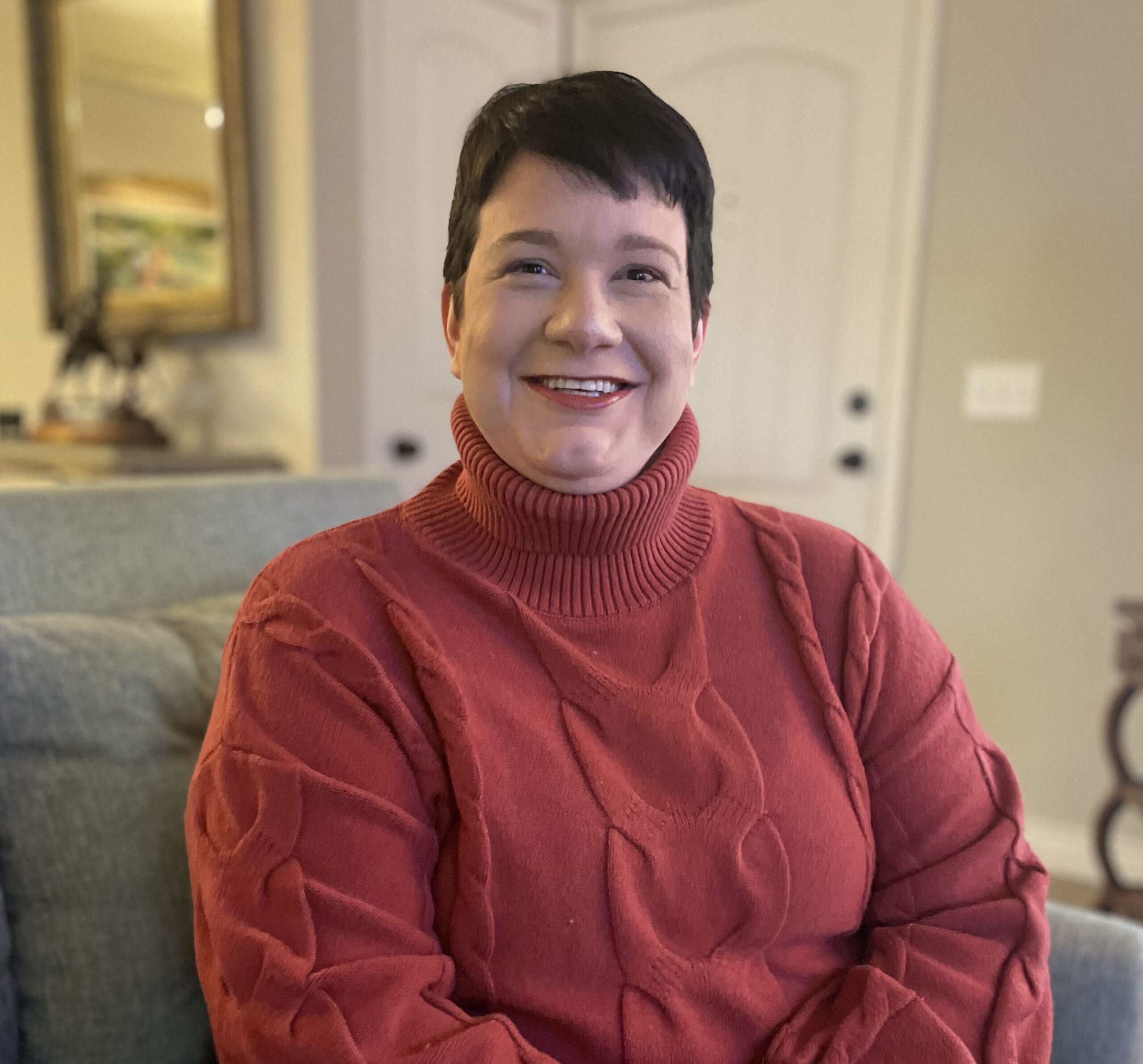 Laynie Hankins sitting on a couch smiling