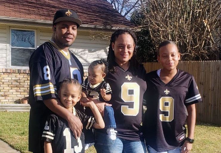 Shametria Turner standing with her family outside a house smiling