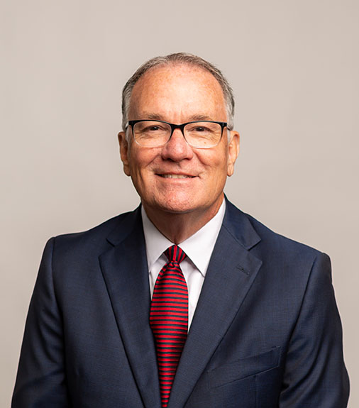 Dr. Newman sitting and smiling with neutral background