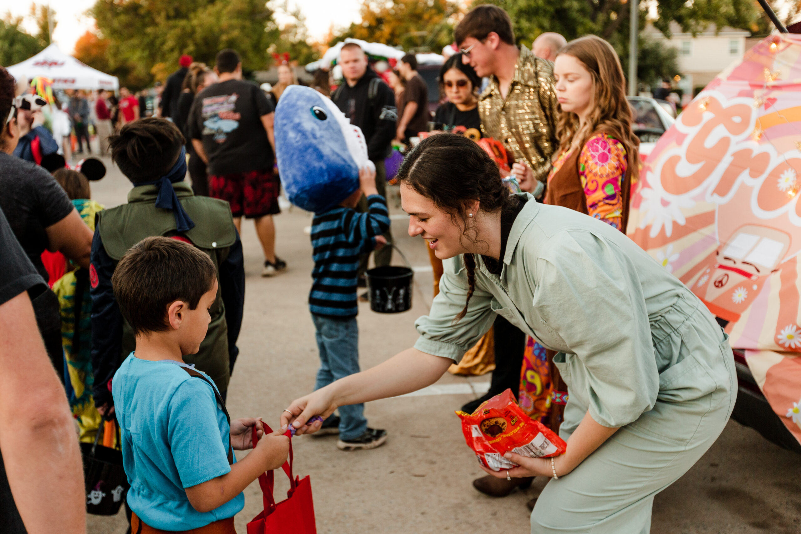 A girl giving a child candy for Halloween