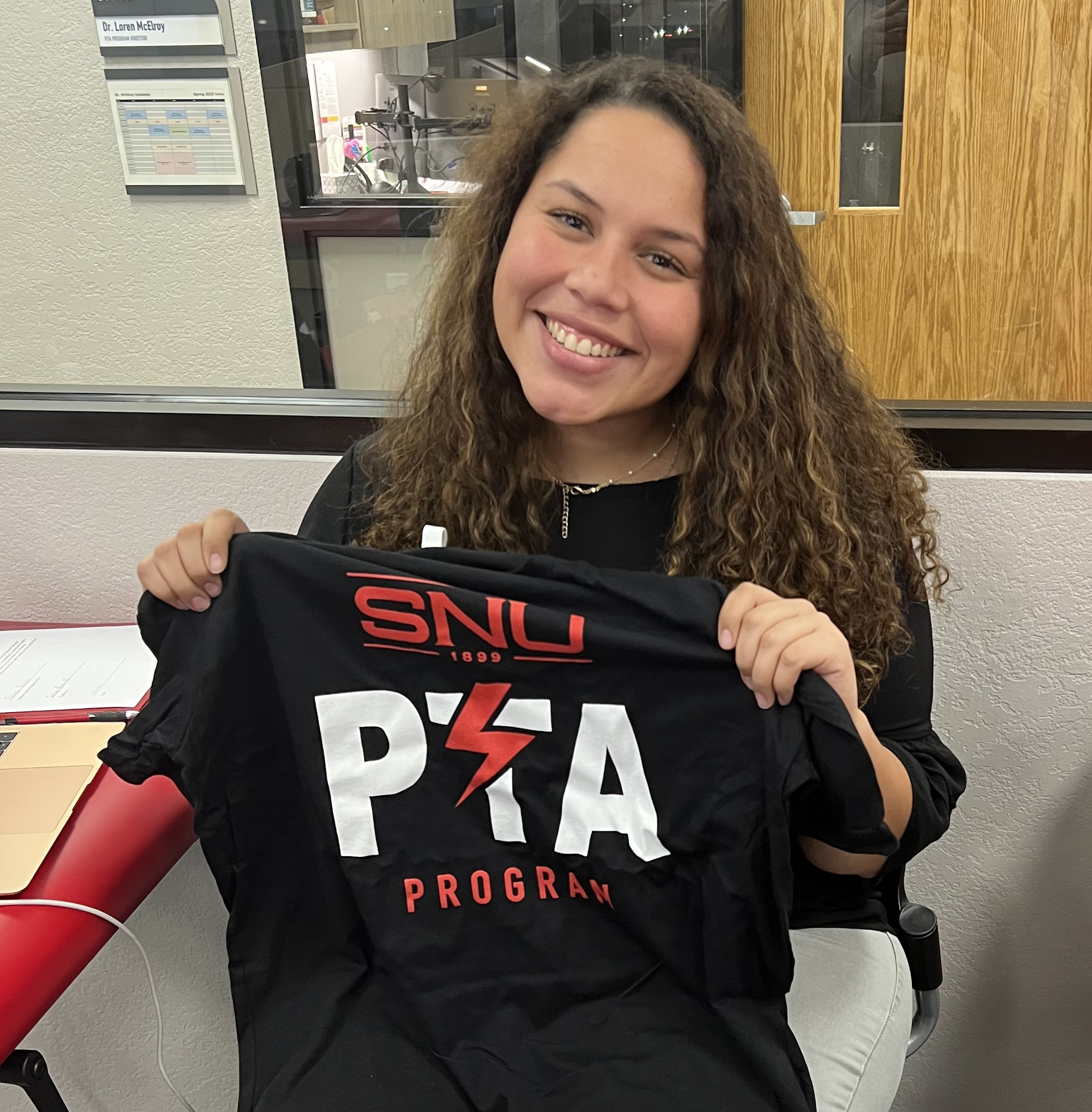 Talea Powell holding shirt from SNU's PTA (Physical Therapist Assistant) program